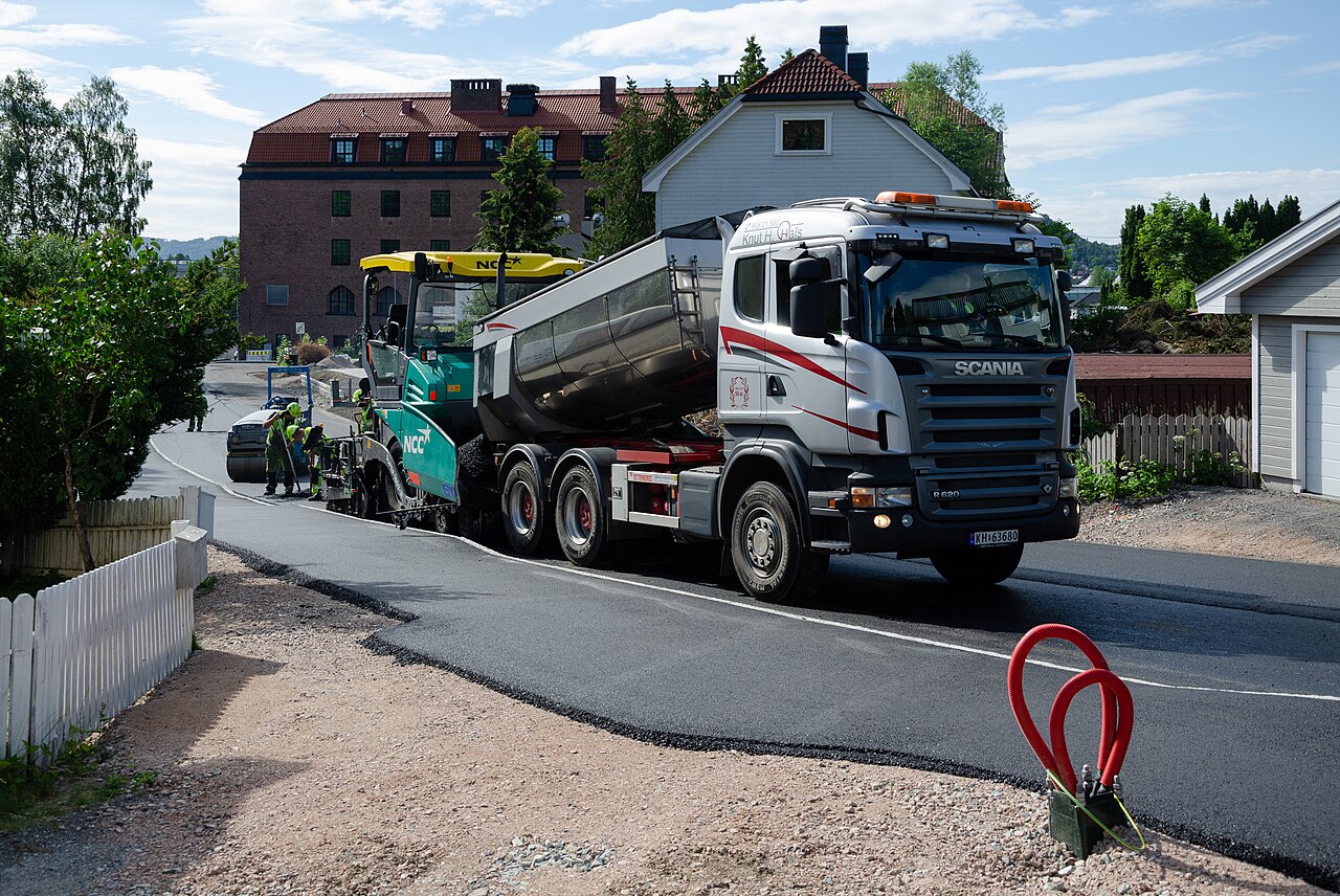 Asphalt paving crew laying a new road surface