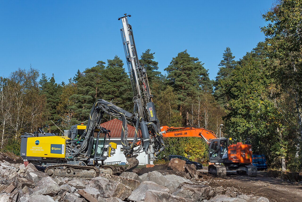 Drill rig and excavator on a rock excavation site