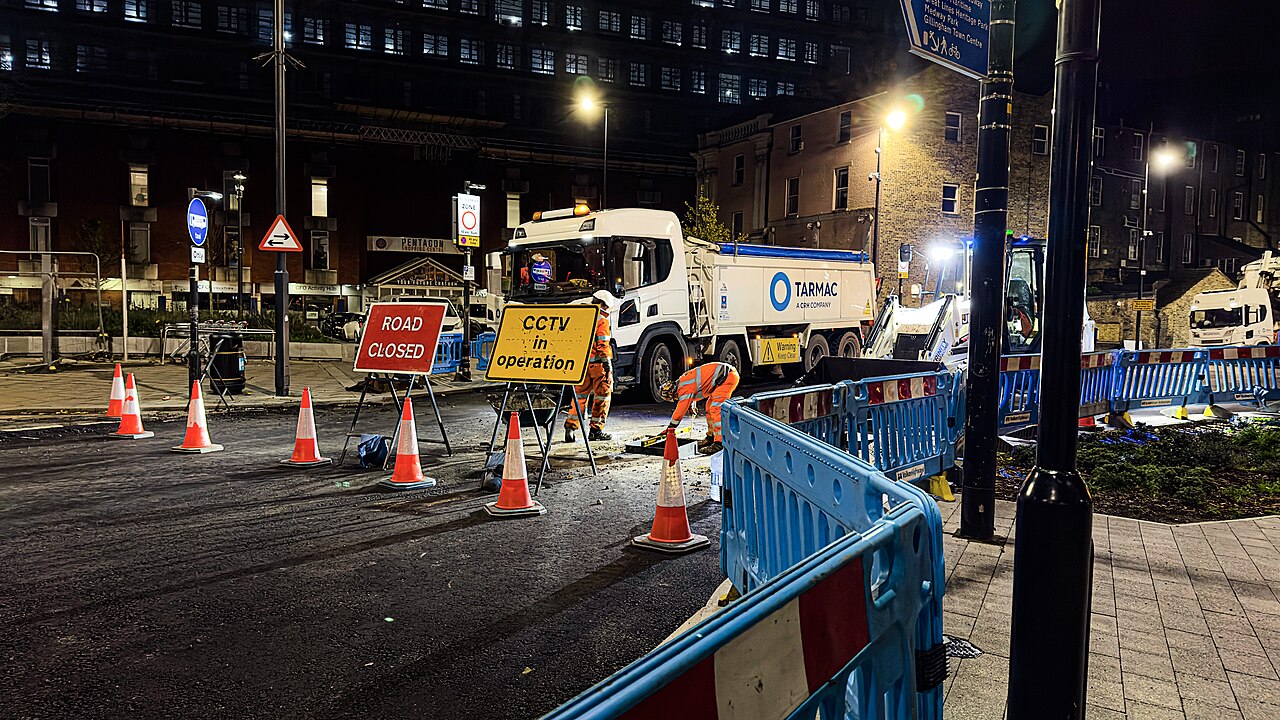 Night-time road resurfacing works behind traffic barriers