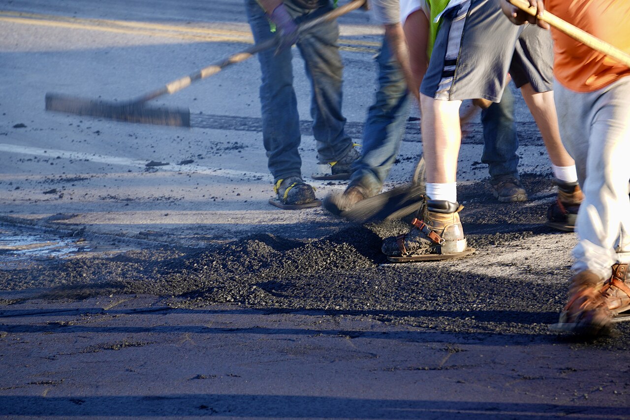 Crew raking hot asphalt on a road